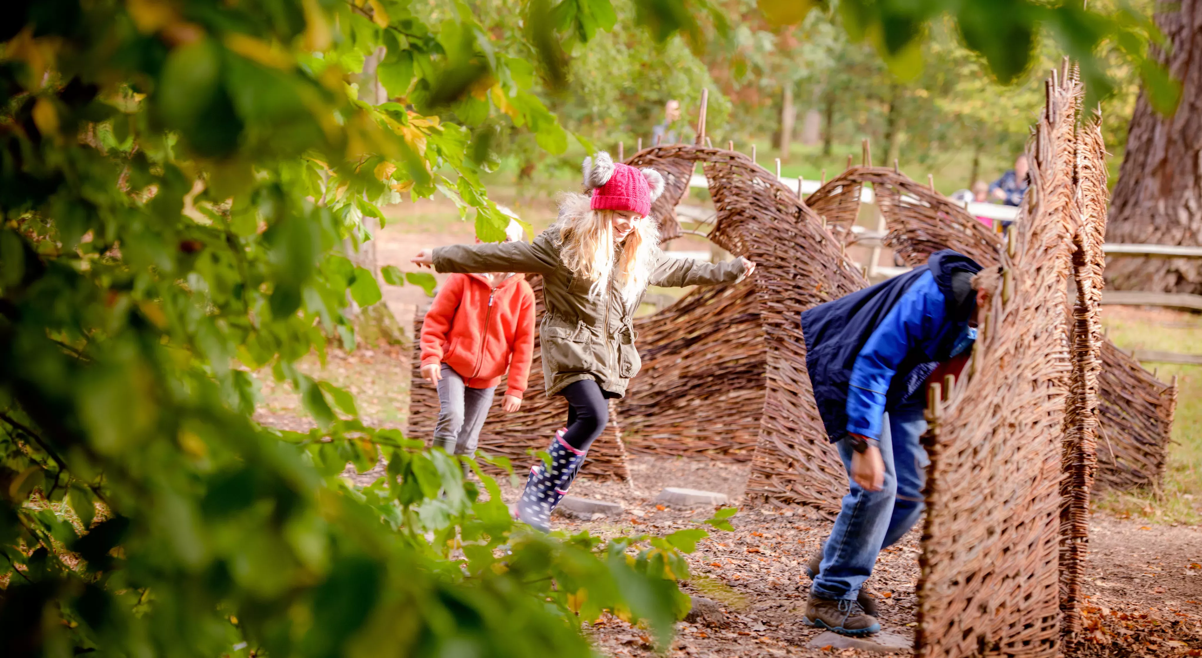 Tree Trunk Trek at Wakehurst in Autumn, Jim Holden © RBG Kew Children running through a woodland playground