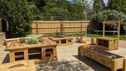 Wooden furniture and play tables in the Mud Kitchen at Wakehurst