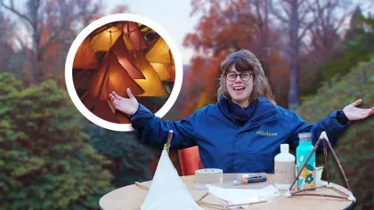 Composite image: smiling woman seated behind a table of craft supplies with her arms spread wide, against a backdrop of trees. Inset: a collection of glowing handmade lanterns