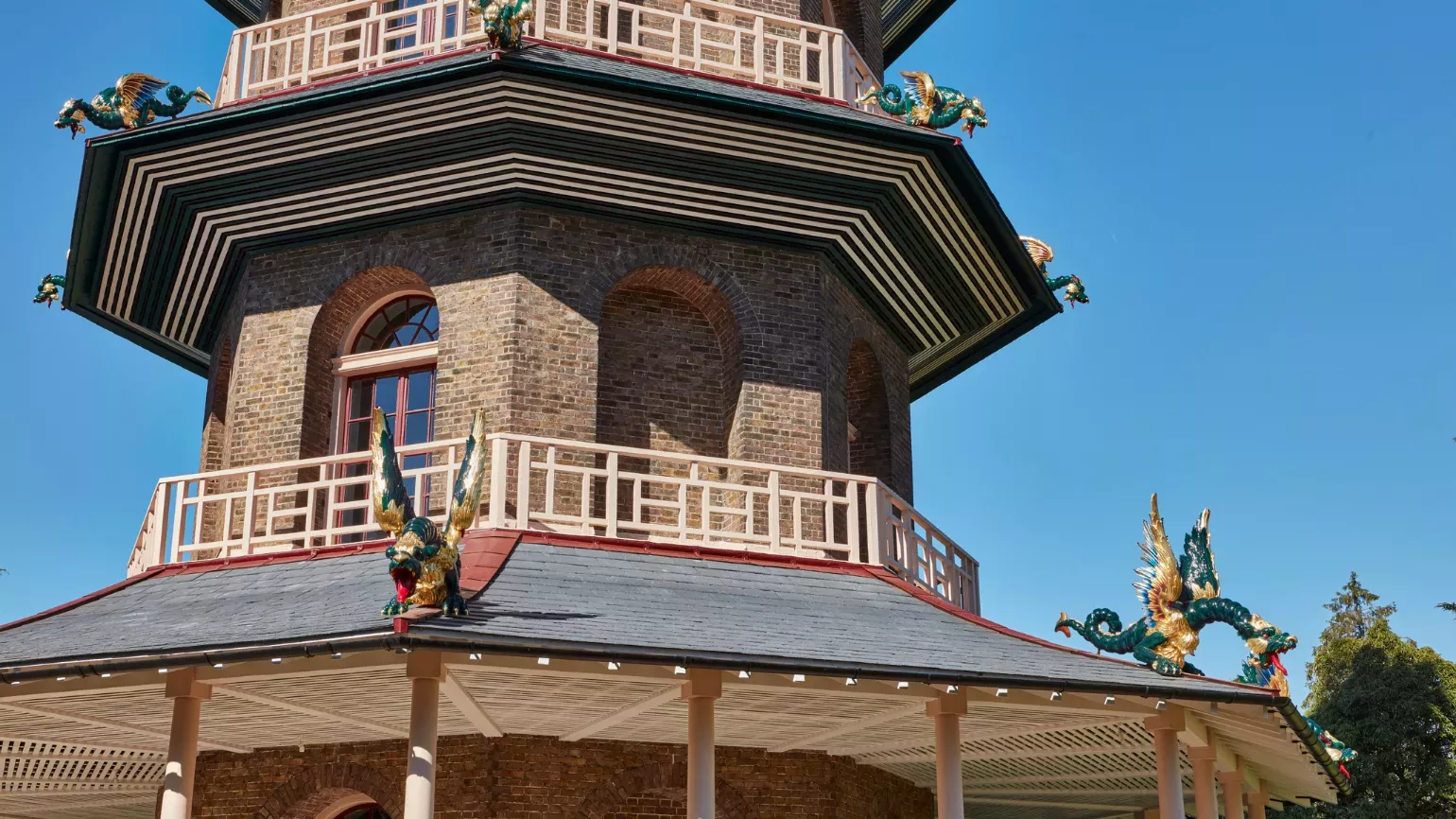 Great Pagoda © Historic Royal Palaces Low angle shot of the Great Pagoda with a blue sky in the background. Dragons can be seen adorning the outside of the building.