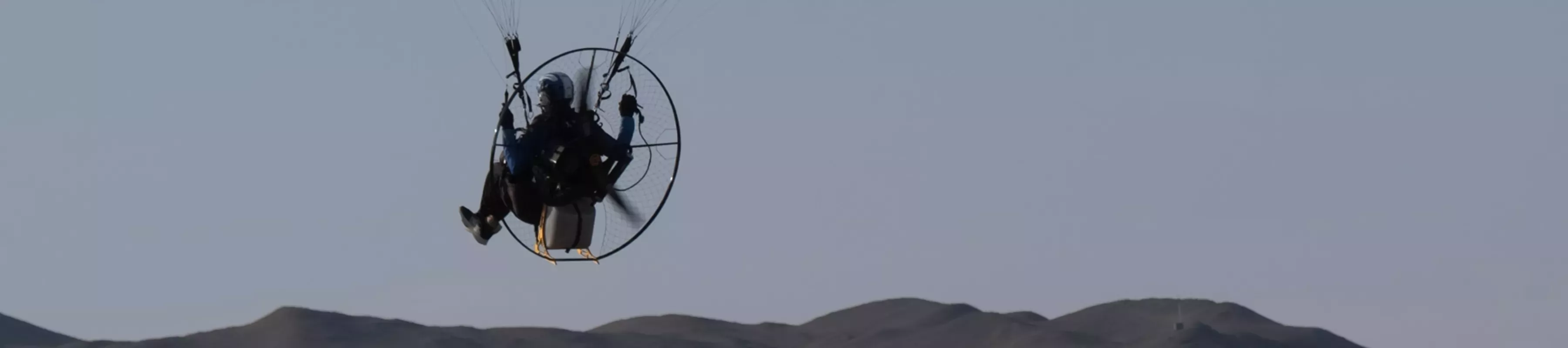 Paramotoring in Peru A person on a paramotor in the sky over faraway hills