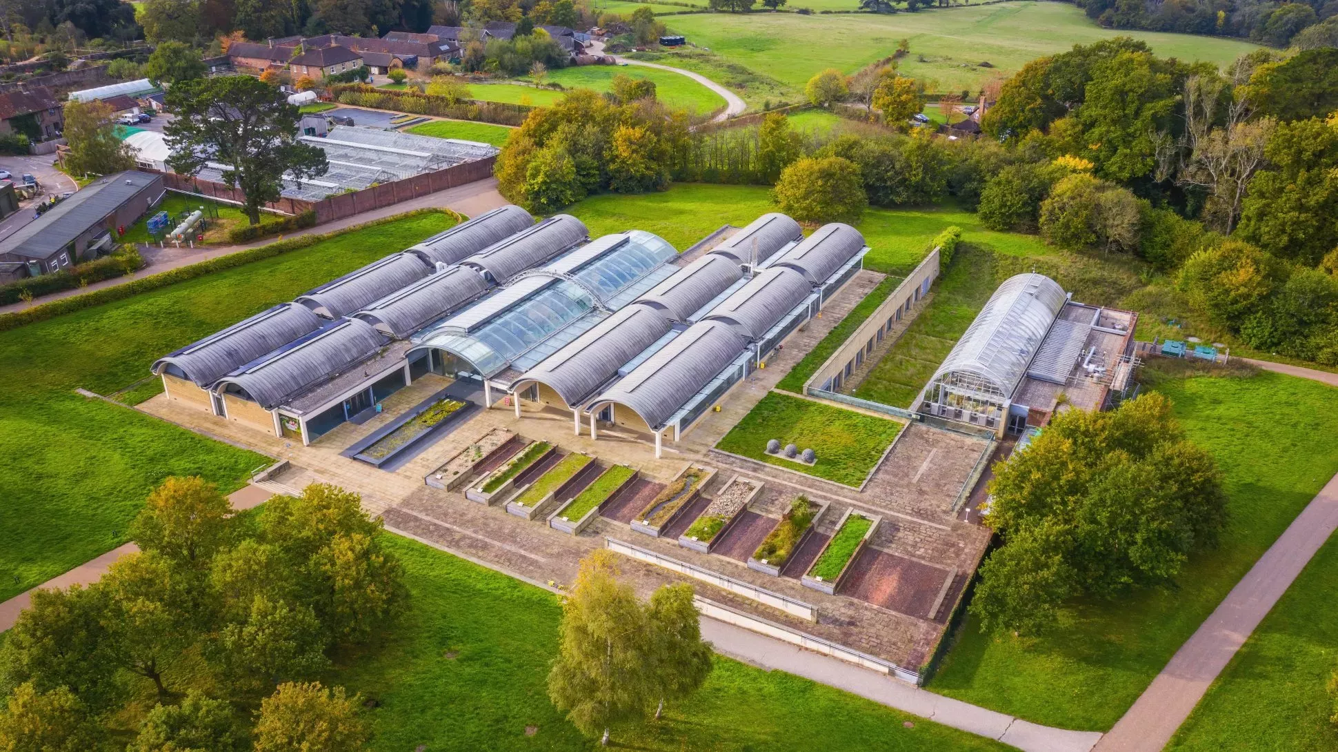 Aerial view of the Millennium Seed Bank, Visual Air © RBG Kew Large glasshouse in a green landscape from above