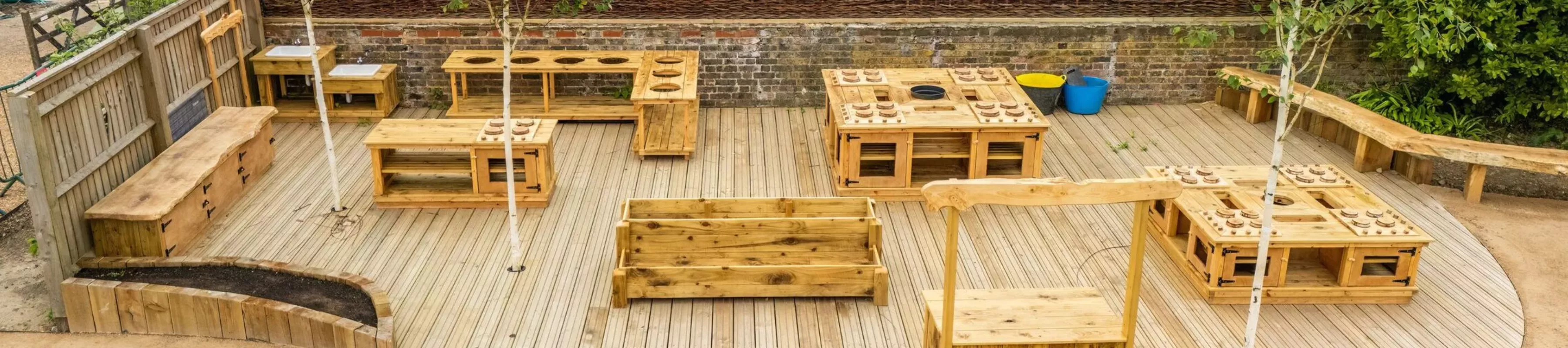 Wakehurst Children's & Community Garden, Visual Air © RBG Kew A drone shot of the Children's & Community Garden at Wakehurst, comprising wooden ovens, and tables.